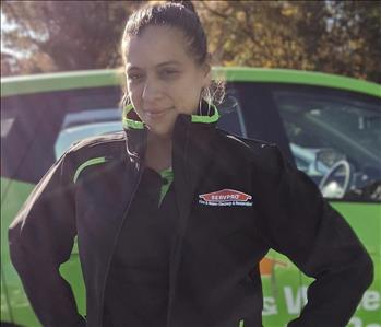 Servpro of Freehold shares picture of one of their female project managers and standing in front of their SERVPRO vehicle.