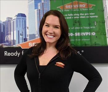 Servpro of Freehold shares picture of one of their project managers smiling and standing in front of a SERVPRO Ad picture. 